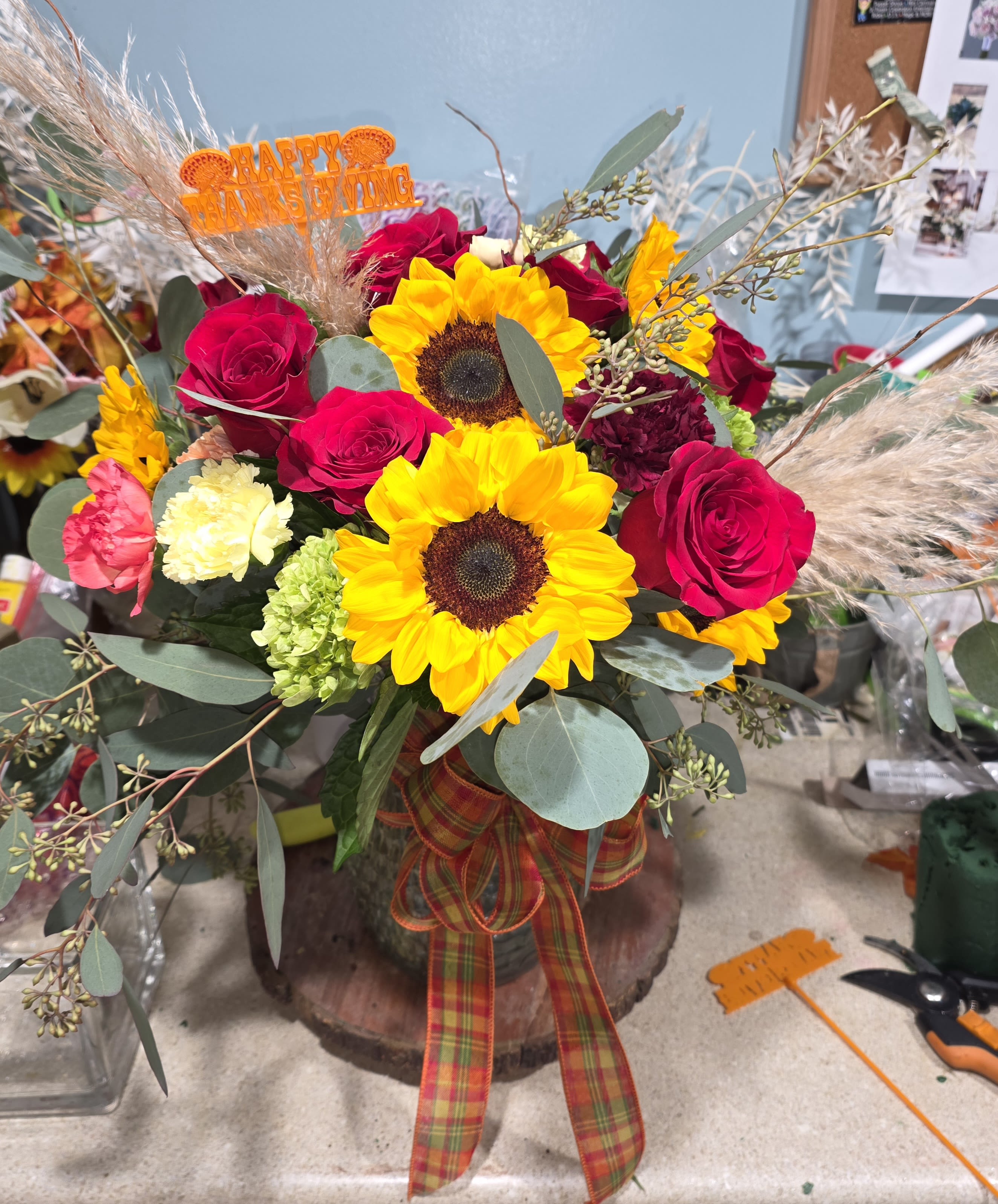 Falling in love - Beautiful, large fall arrangement, Hydrangea, carnation, tall sunflower blooms, red roses, lush greenery adorned with beautiful fall oak leaves and pampas grass.