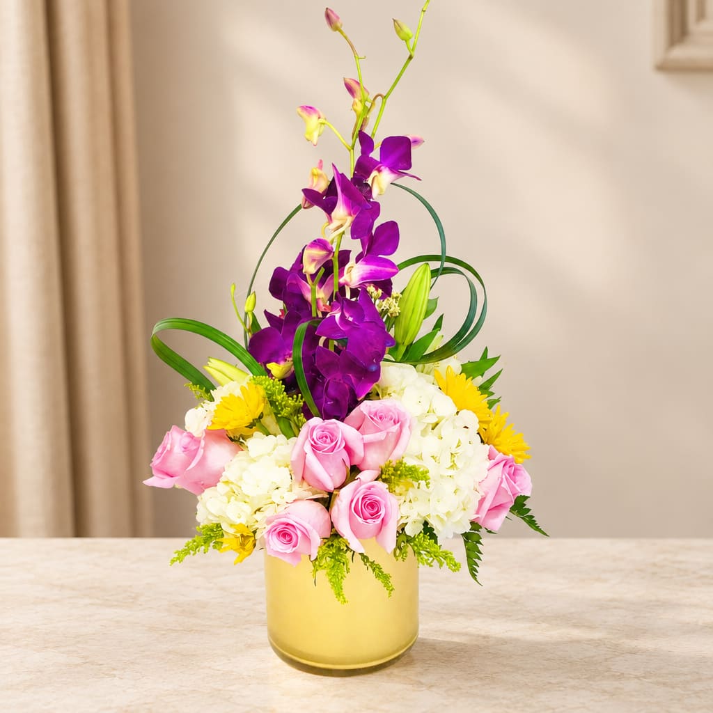 Pink roses and white hydrangeas in a yellow vase with purple orchids
