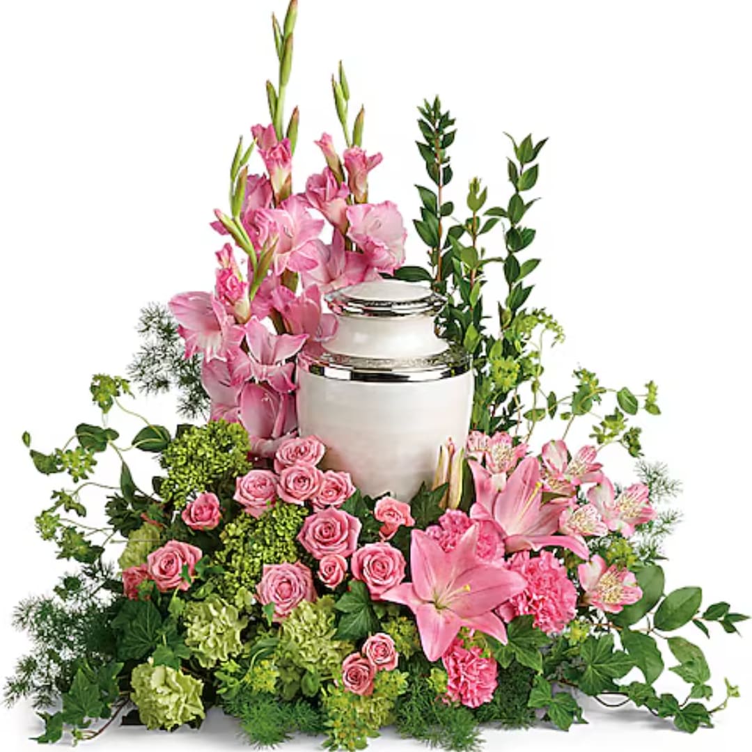 Pink lilies and roses arranged around a white urn