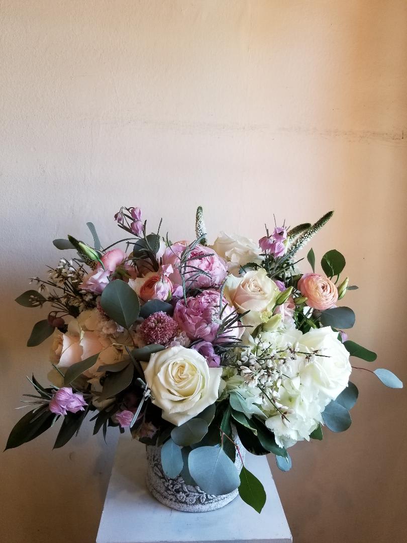 Bouquet of white, pink, and peach flowers in a decorative vase