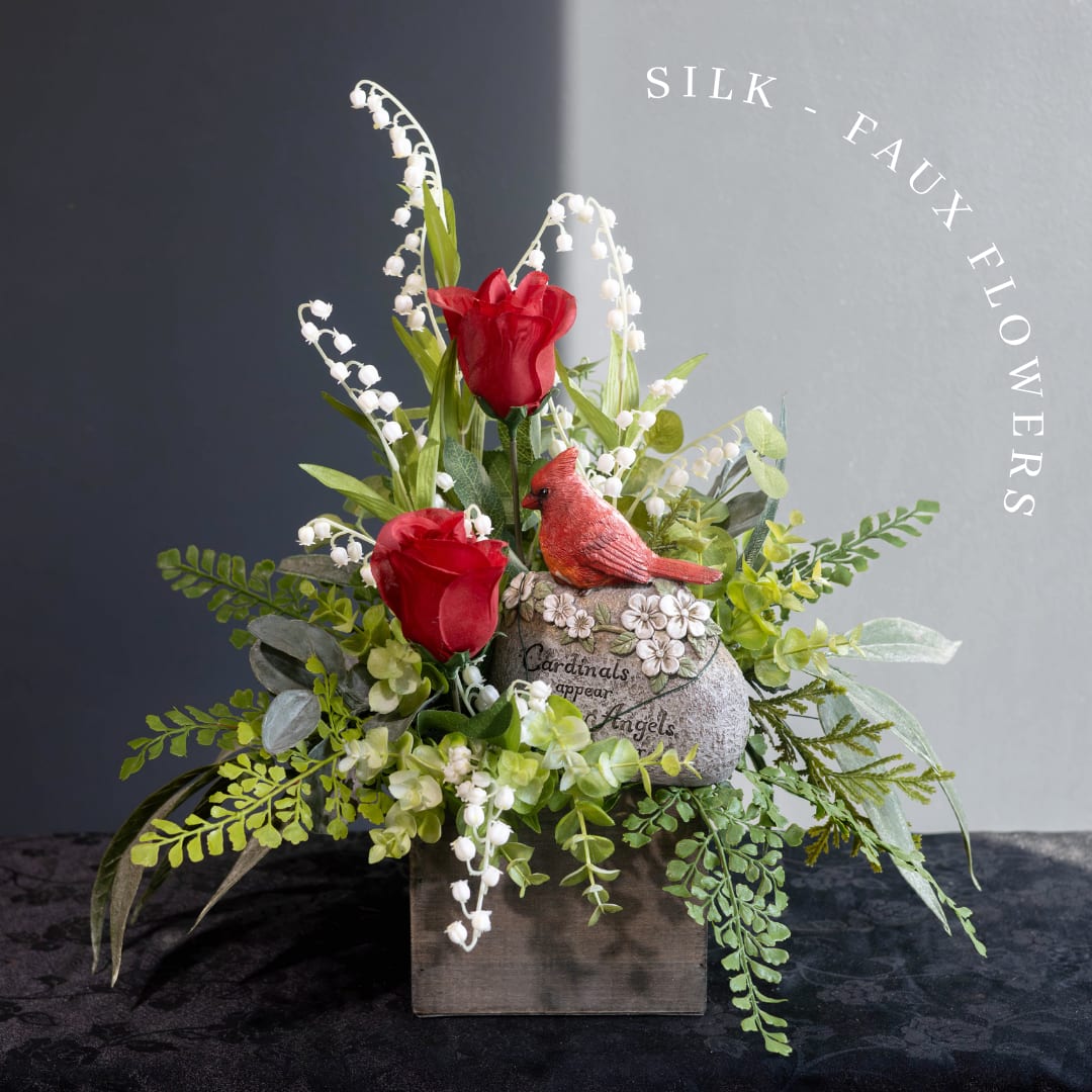 Silk red roses and white lily-of-the-valley in a rustic box with a cardinal figurine