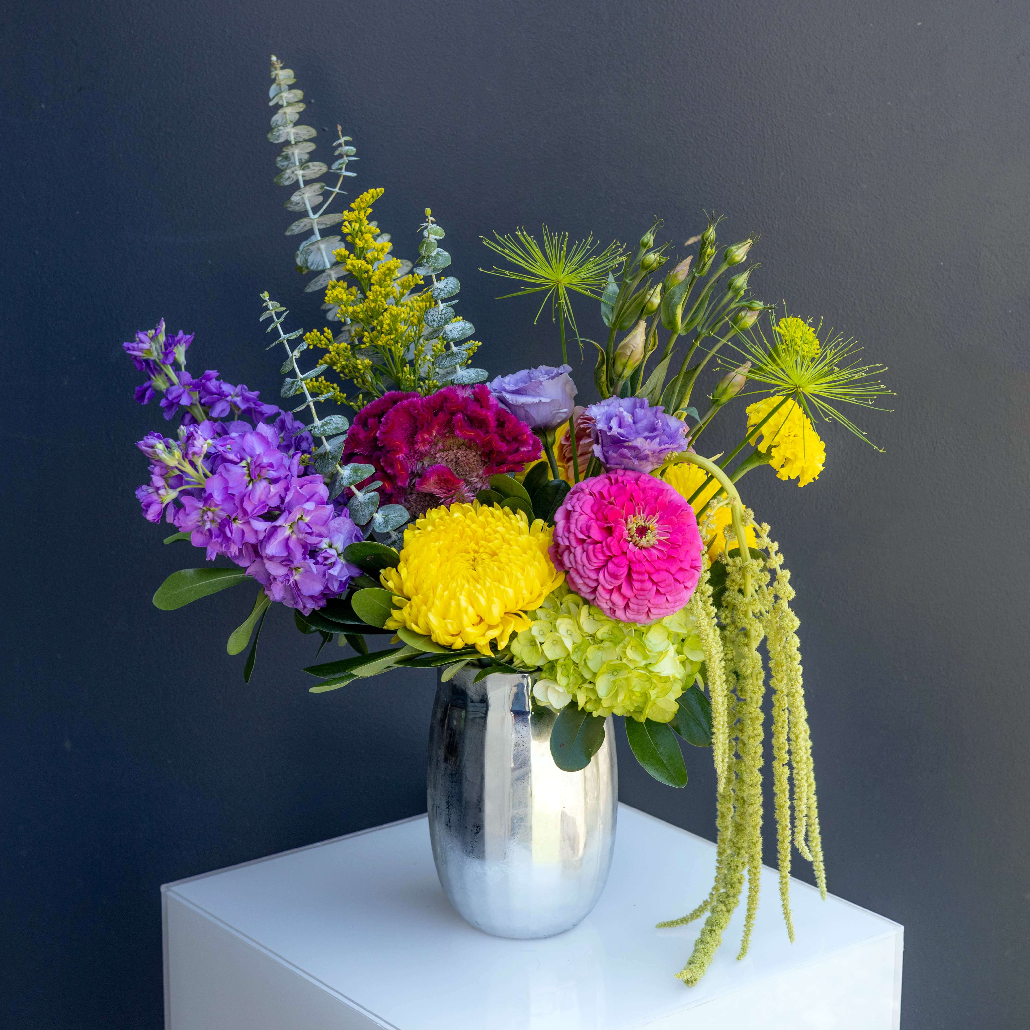 Colorful mixed flower arrangement in a silver vase