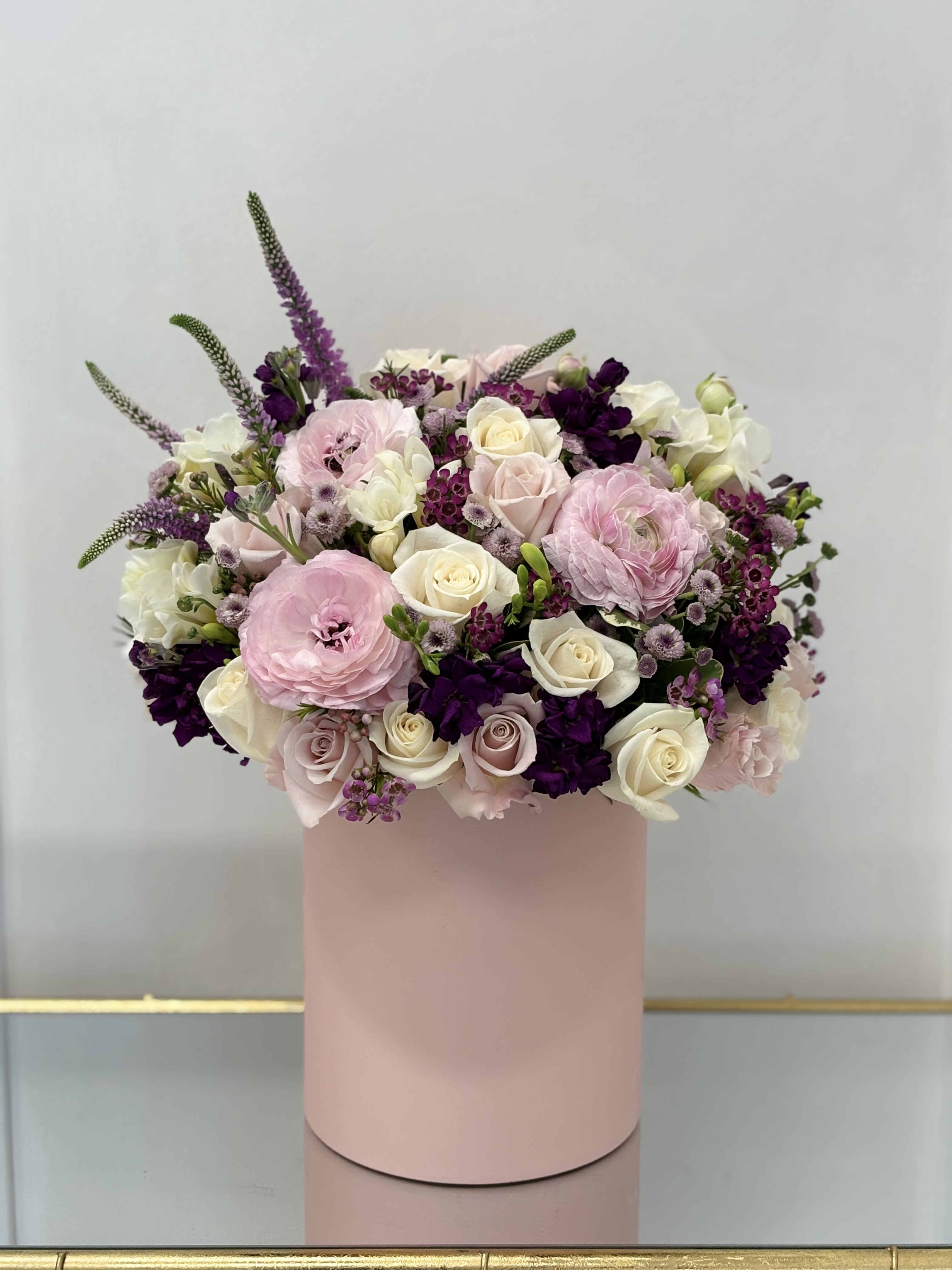 Pink and white floral arrangement in a blush cylindrical box