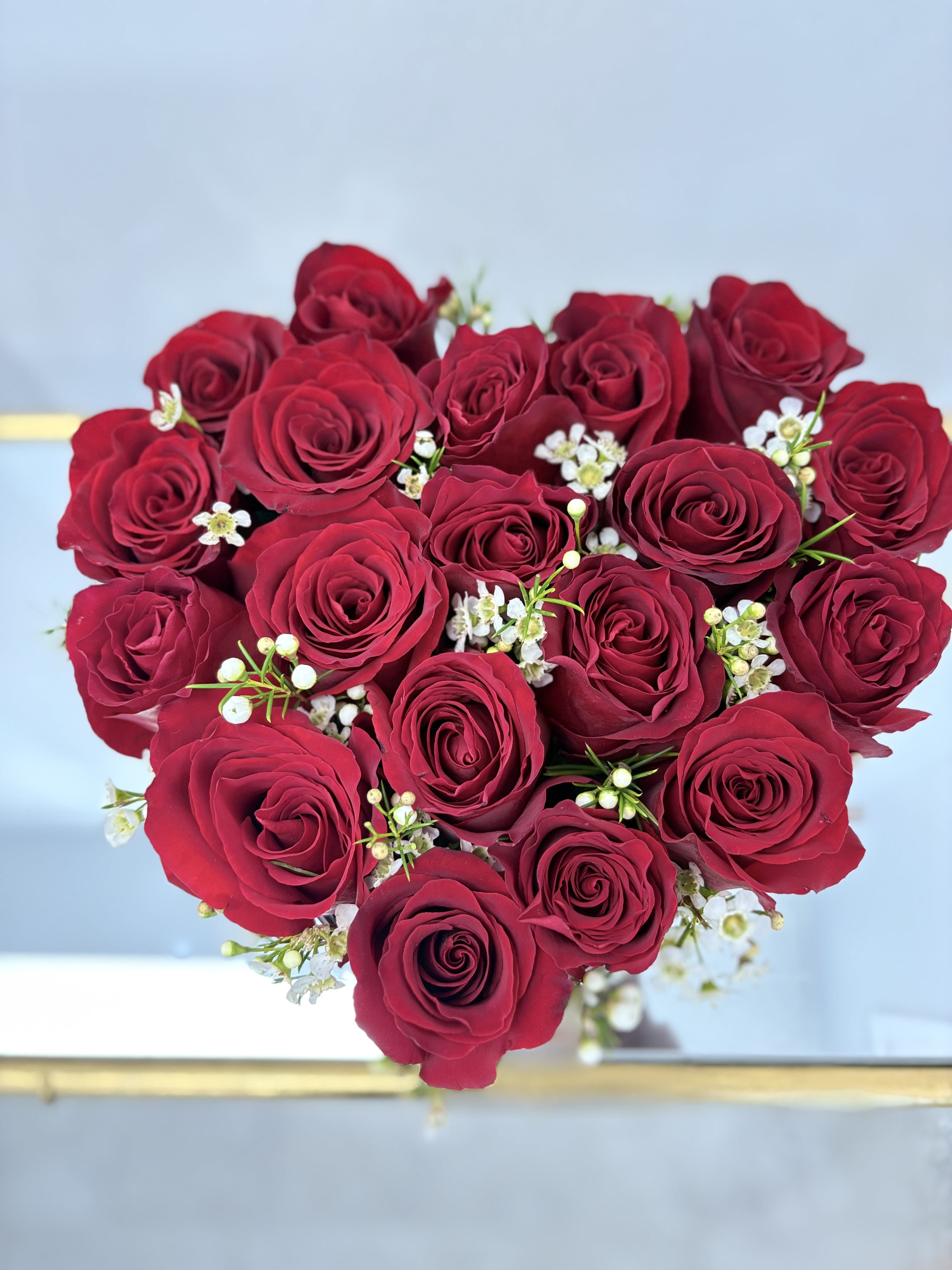 Bouquet of deep red roses with small white filler flowers