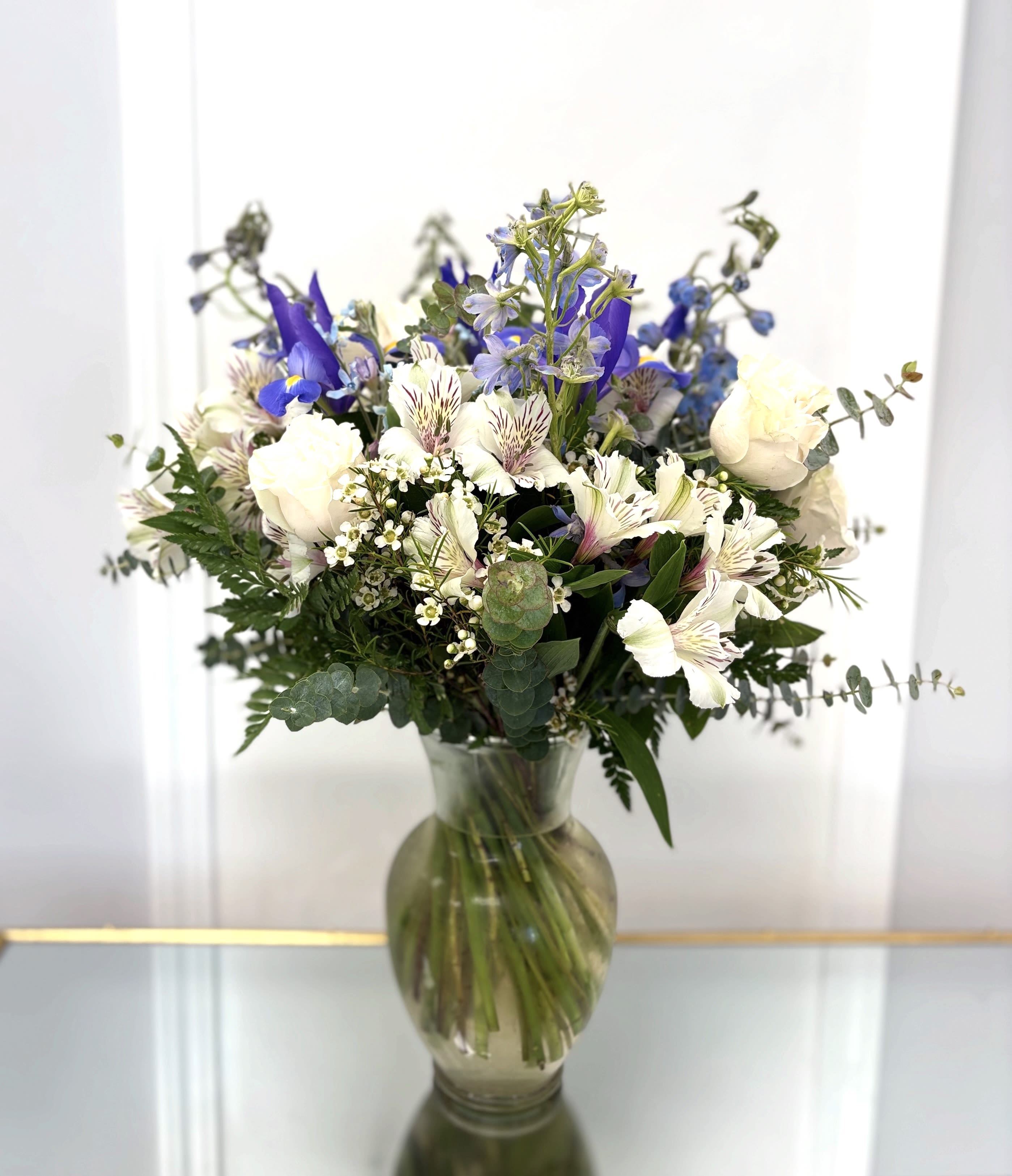 Bouquet of white and blue flowers in a glass vase