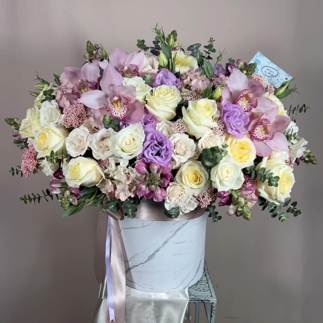 Large pastel bouquet in a marble-look hatbox with a satin ribbon