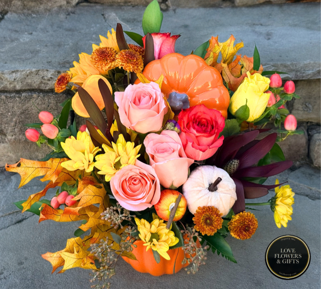 Autumn floral arrangement in a pumpkin container with roses and mums
