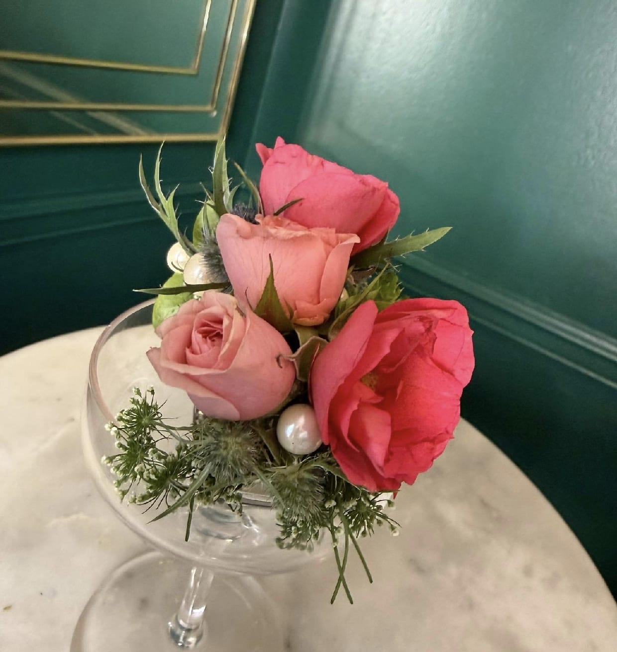 Elastic Corsage by Evergreen Elegance  - Three pink roses with green foliage and white pearl accents.