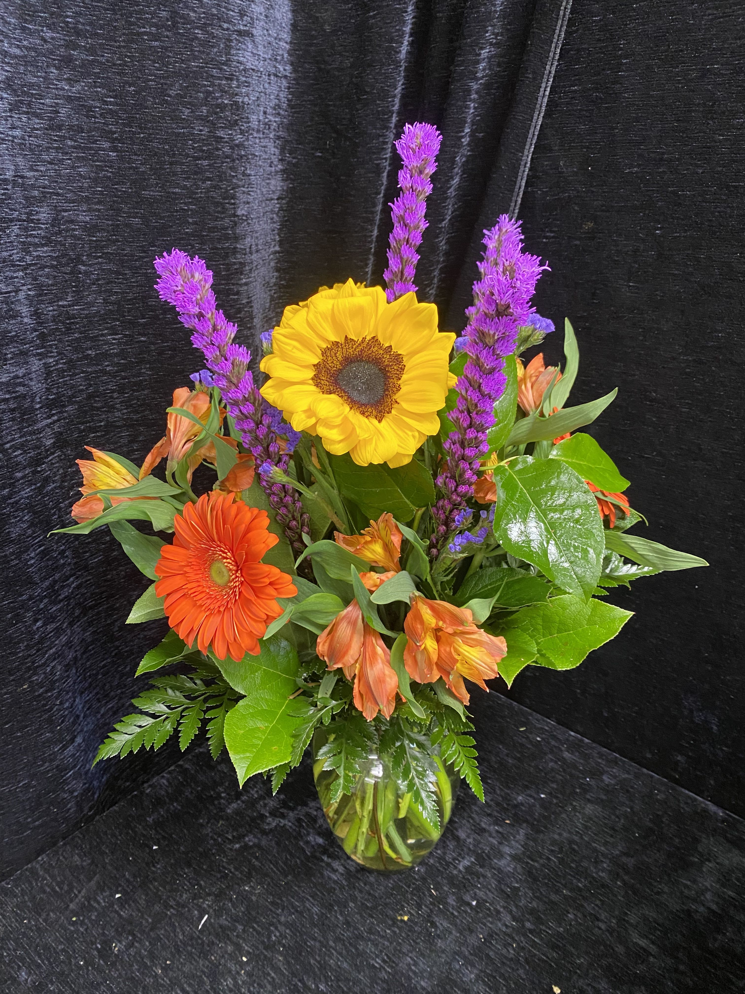 Cat Dad - A bold flower arrangement for Dad, Mom or any cat lover in your life. Choose this cheerful arrangement of cat safe flowers for Father's Day, a birthday, or to say "you're the best". This floral design pairs the warm sunlit tones of gerbera daisies &amp; sunflowers with cool purple accents and fresh green foliage for a textured, eye-catching look. All blooms are listed as cat safe by the ASPCA for a worry-free gift.To keep it looking fresh, change the water every few days and trim the stems at an angle when you refresh the vase.