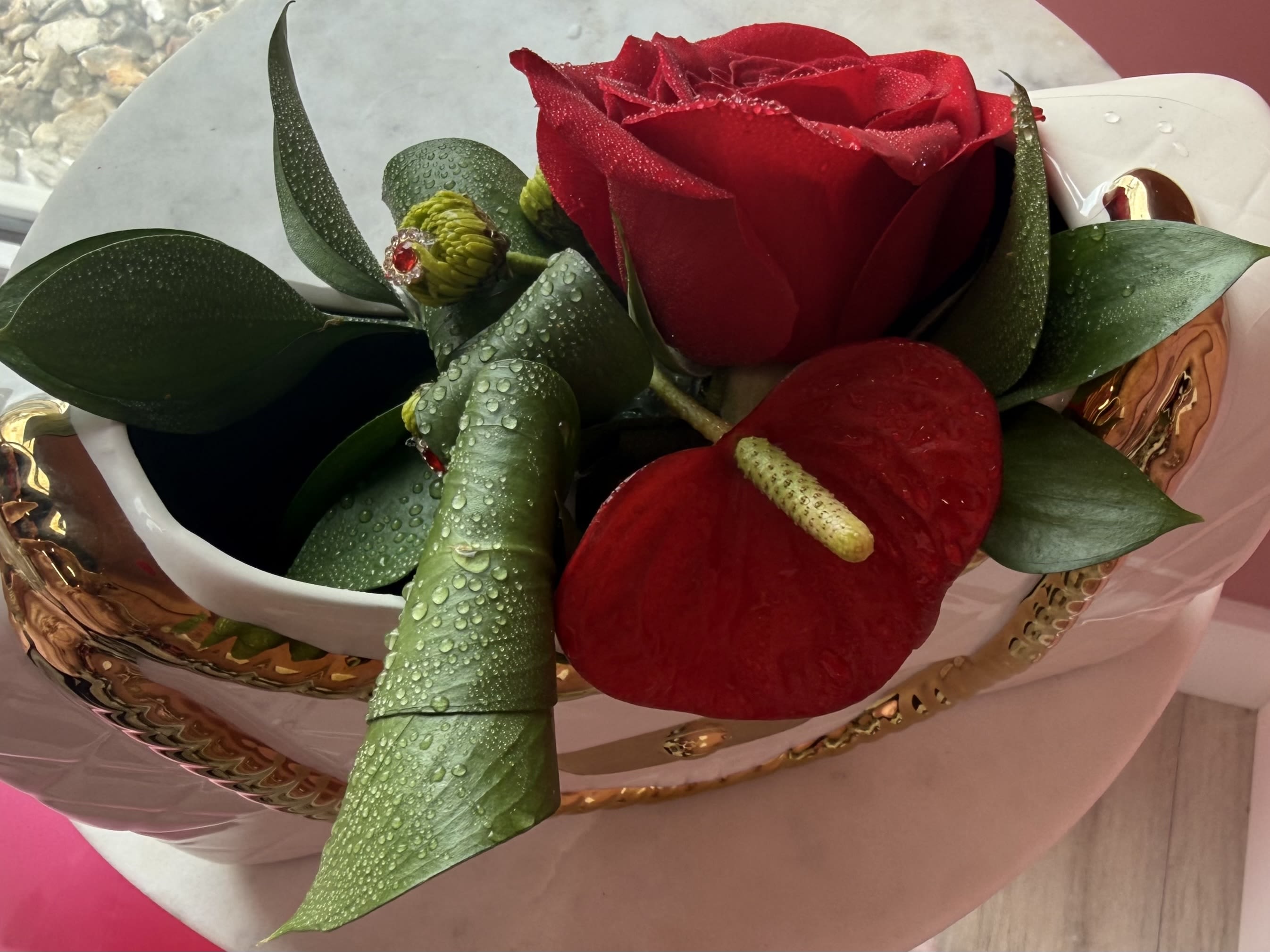 Premier Corsage by Evergreen Elegance  - Best of the best quality blooms for this cuff corsage...This more elaborate piece features the classic red rose and anthurium. It is accented with red diamond gemstones and various types of greenery. This corsage includes a cuff band that can come in silver or gold.
