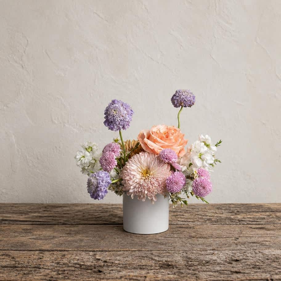 Small pastel flower arrangement in a white vase