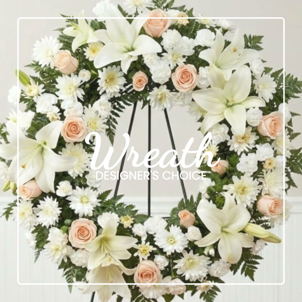 White floral wreath with pale peach roses on a stand