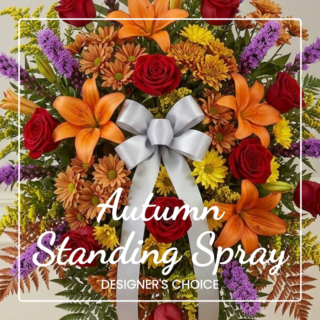 Autumn standing spray with red roses, orange lilies, and a silver bow