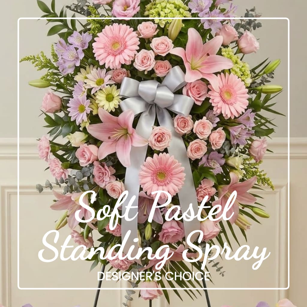 Pastel standing spray with pink lilies, daisies, and roses on a ribboned easel