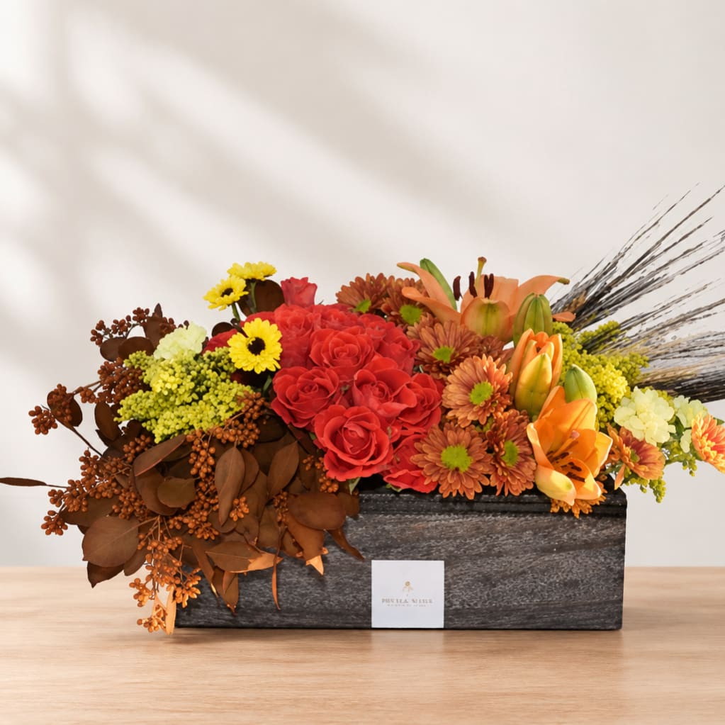 Mixed floral arrangement in a rectangular black box with red, orange, and yellow blooms