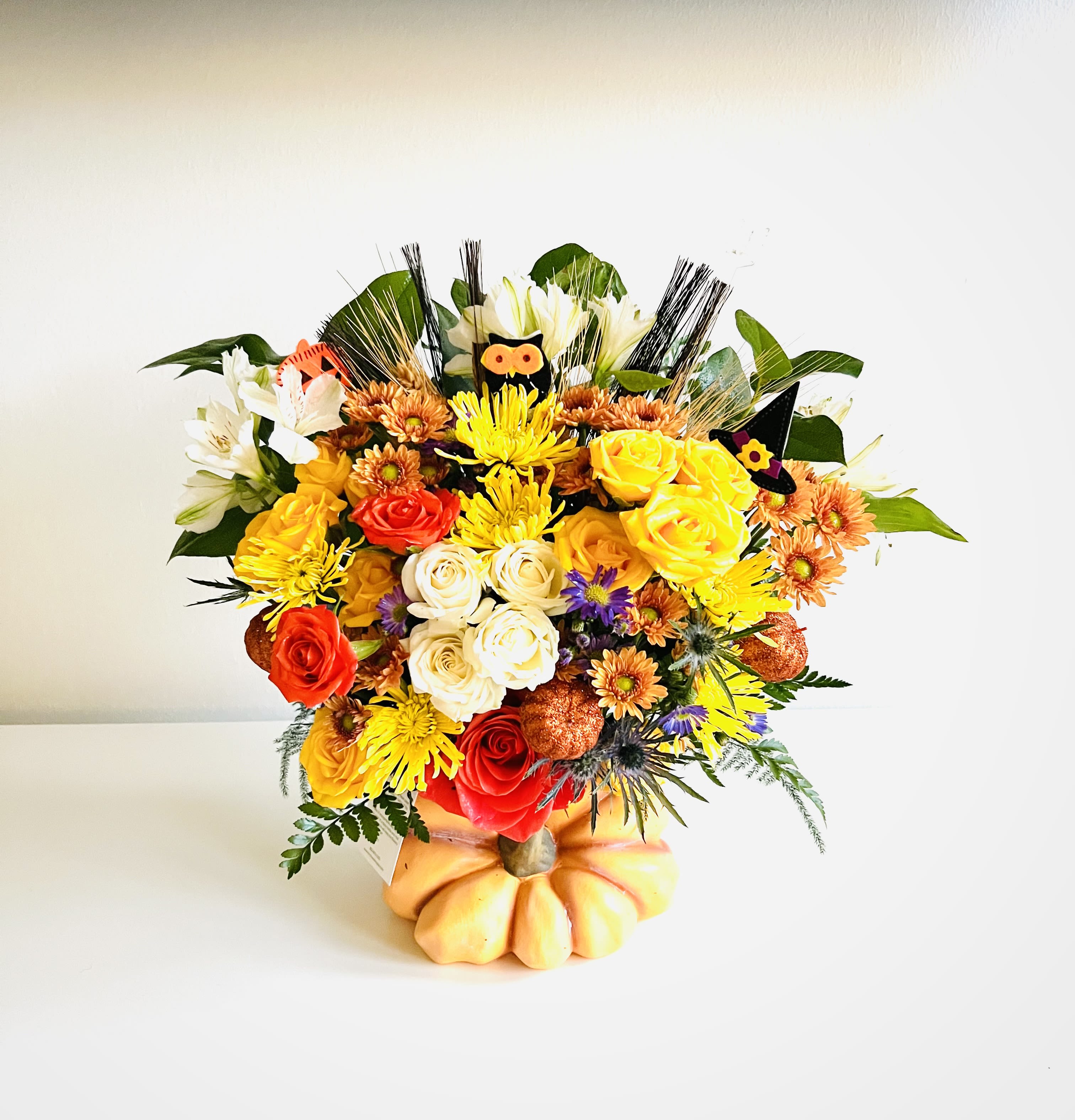 Mixed bouquet of roses and chrysanthemums in a pumpkin-shaped container