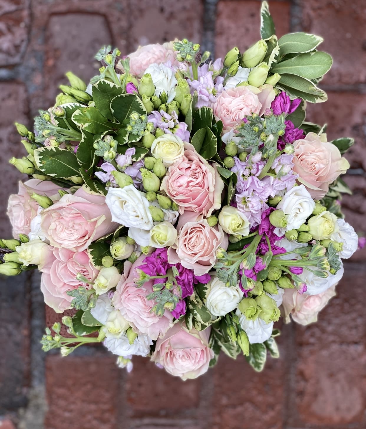 Round bouquet of pink and white roses with lavender flowers