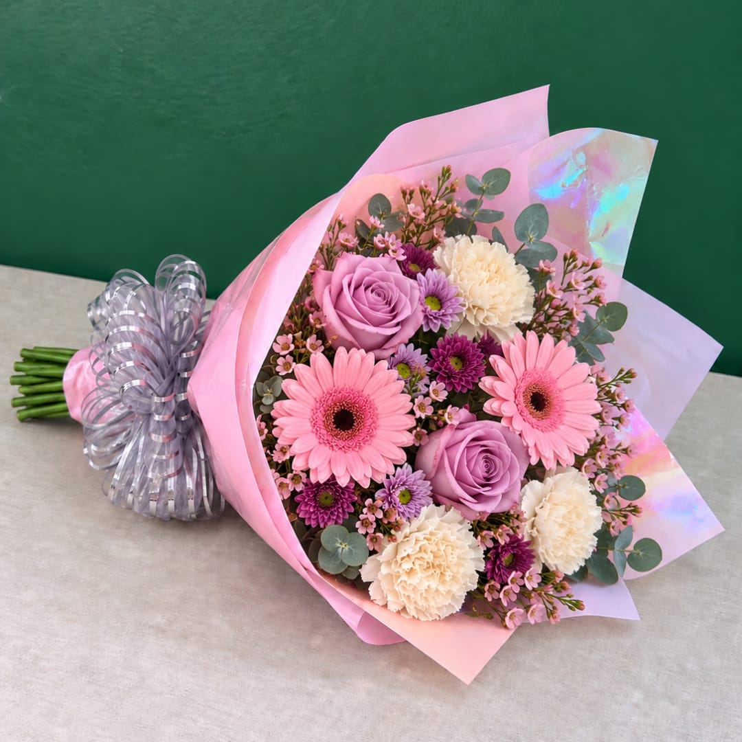 Pink and lavender bouquet with gerbera daisies, roses, and carnations wrapped in pink paper
