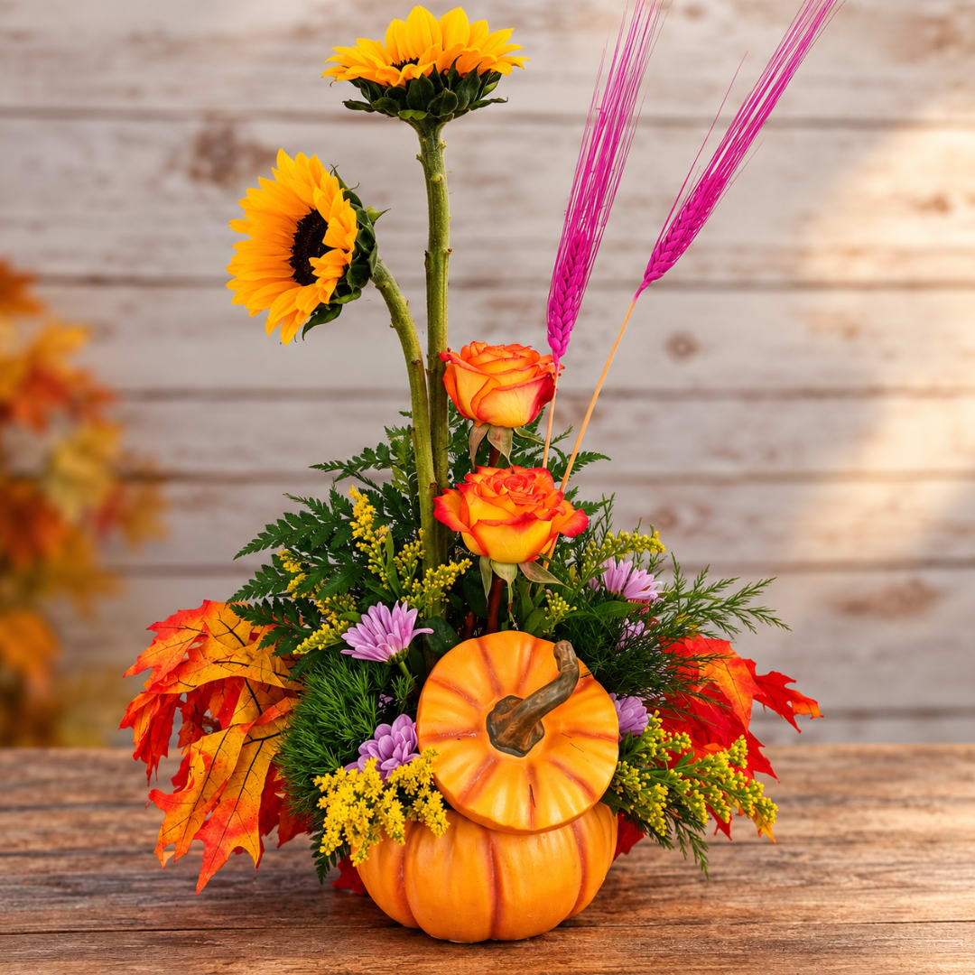Fall floral arrangement with sunflowers, roses, and pumpkins
