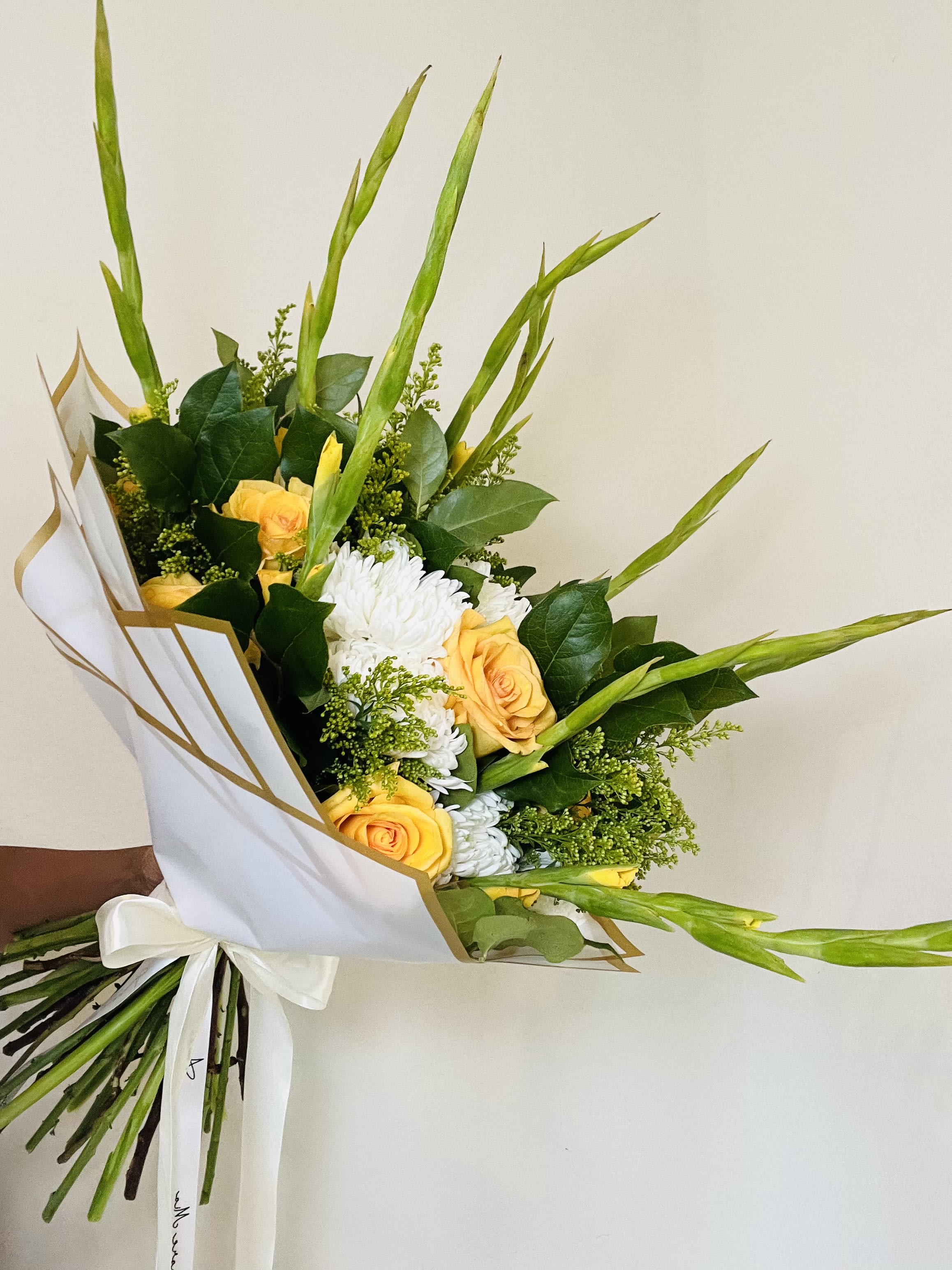 Yellow &amp; White Mixed Flower Bouquet with Greenery - Fresh, modern, and full of natural texture, our Yellow &amp; White Mixed Flower Bouquet with Greenery features a florist-selected combination of soft yellow and white blooms surrounded by an abundance of lush greenery. Long, wispy foliage adds height and movement, creating an airy, garden-inspired design with a unique and contemporary feel.  The fresh green tones with touches of yellow and white make this bouquet a beautiful choice for birthdays, congratulations, thank-you gifts, housewarmings, get-well wishes, spring celebrations, hostess gifts, or simply brightening someone’s day.  Each Amore Mio Roses bouquet is freshly made to order using high-quality seasonal flowers and greenery. Exact flower varieties, shades, foliage, and accent blooms may vary based on availability. Thoughtful substitutions may be made while maintaining the overall yellow, white, and green color palette, style, quality, and value of the bouquet.