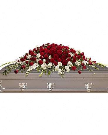 Red and white floral spray on a gray casket