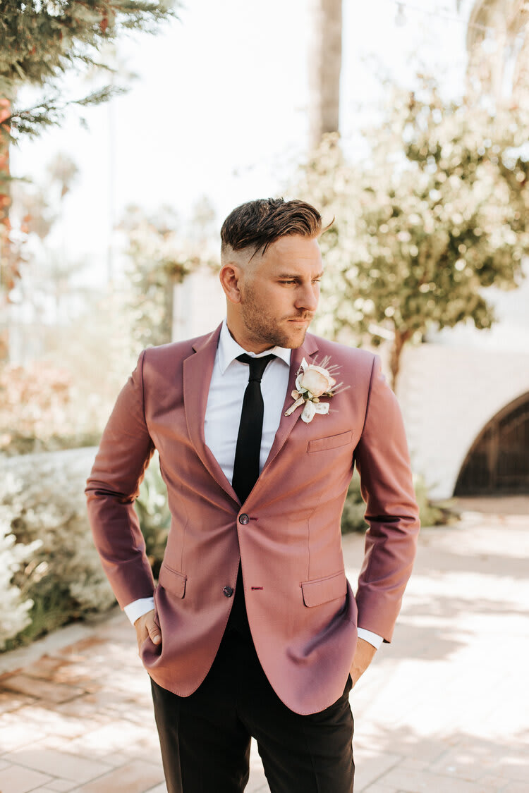 Man in a mauve suit wearing a boutonniere