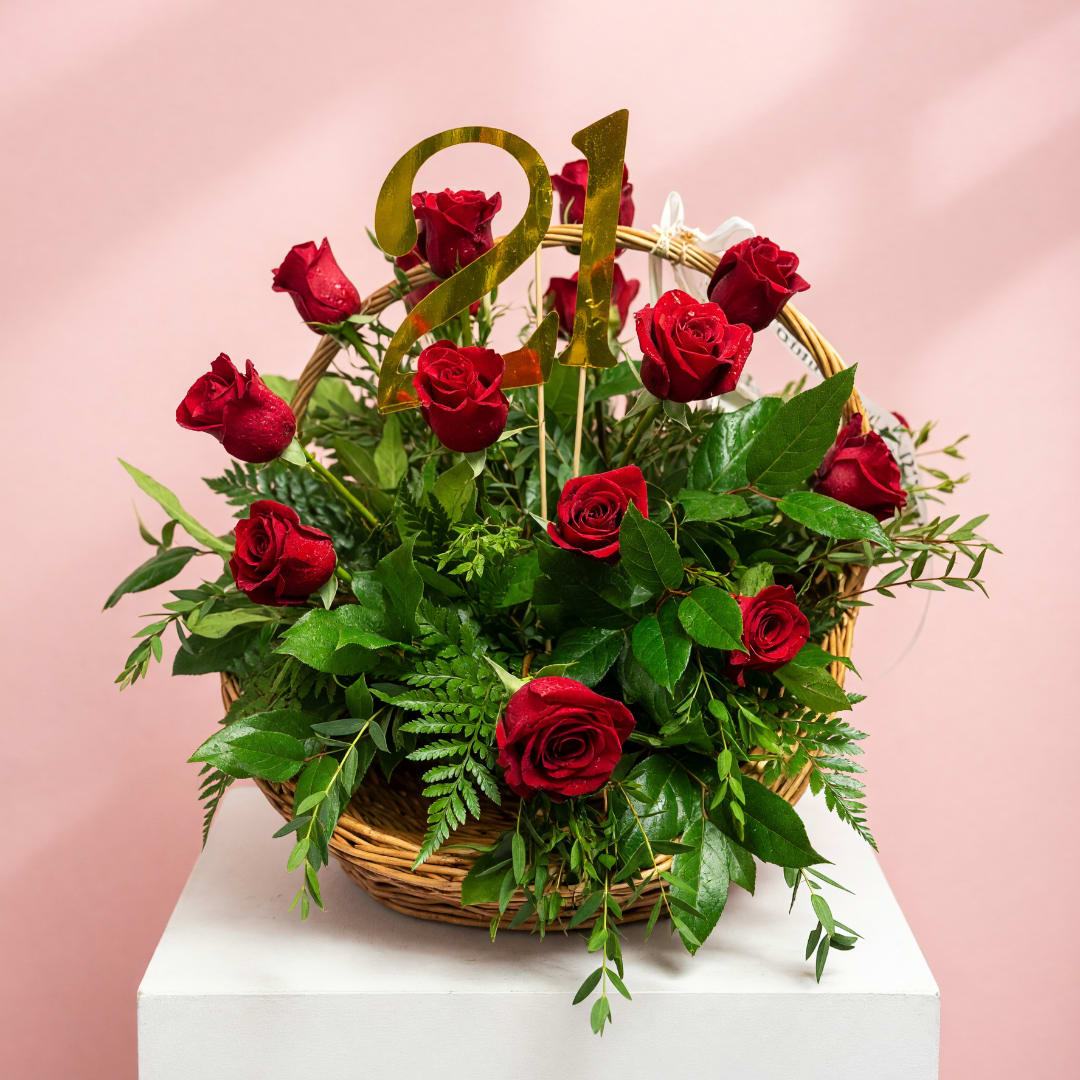 Basket of red roses with a gold "21" topper