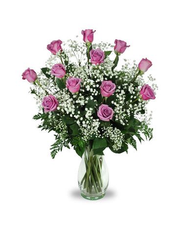 Pink roses in a clear glass vase with white baby's breath