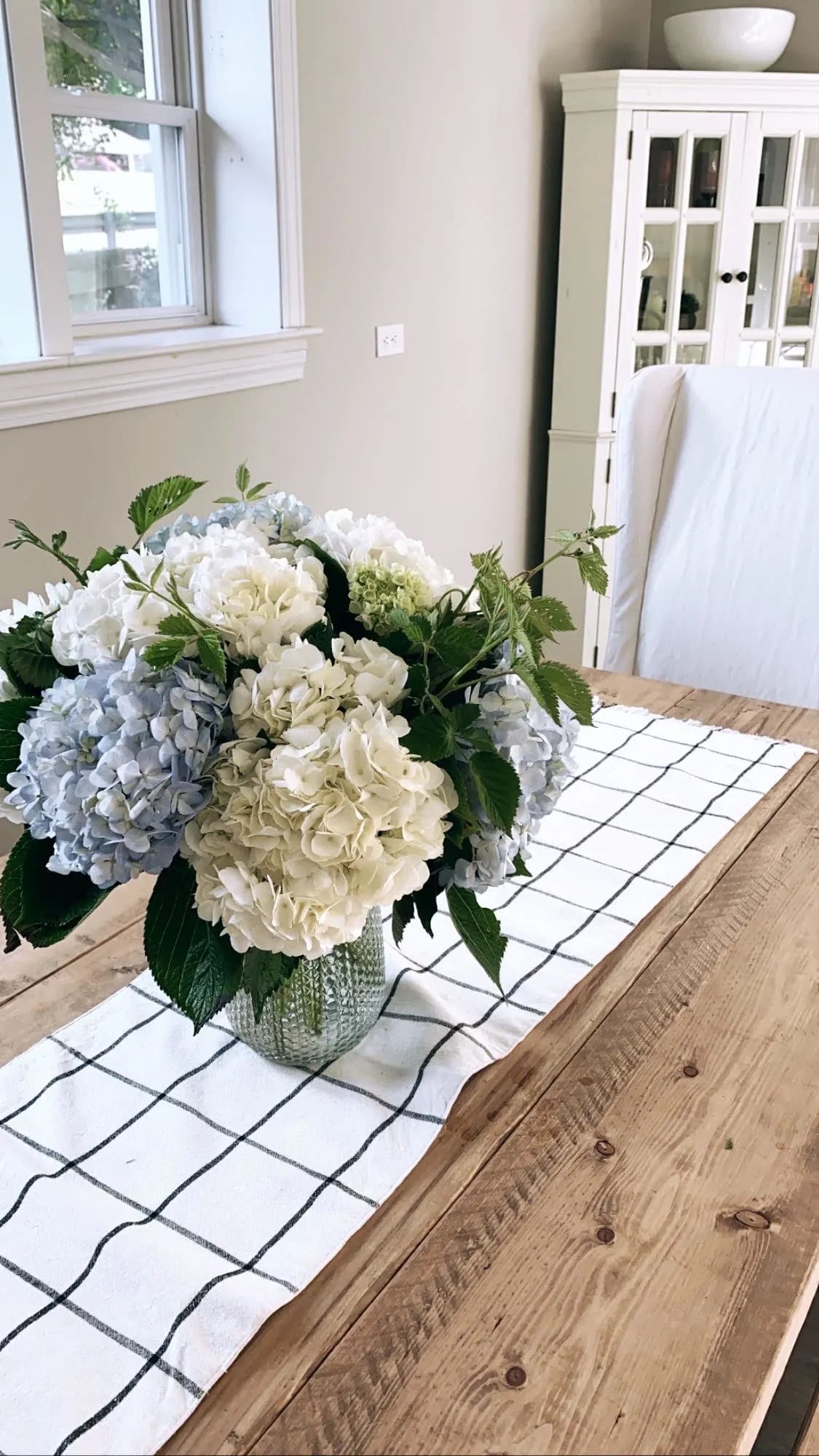 Hydrangea bouquet in a glass vase on a dining table
