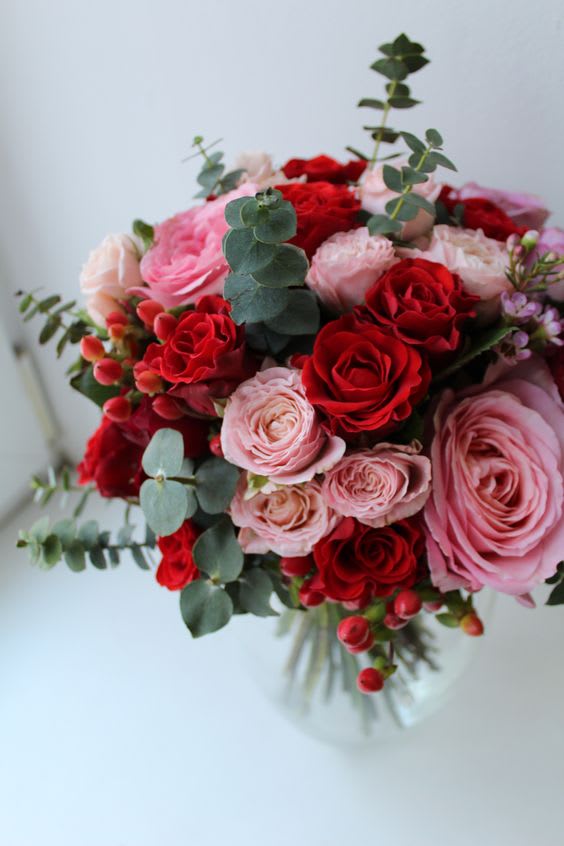 Be Mine - Various garden roses with touches of spiral eucalyptus arranged in a low vase.