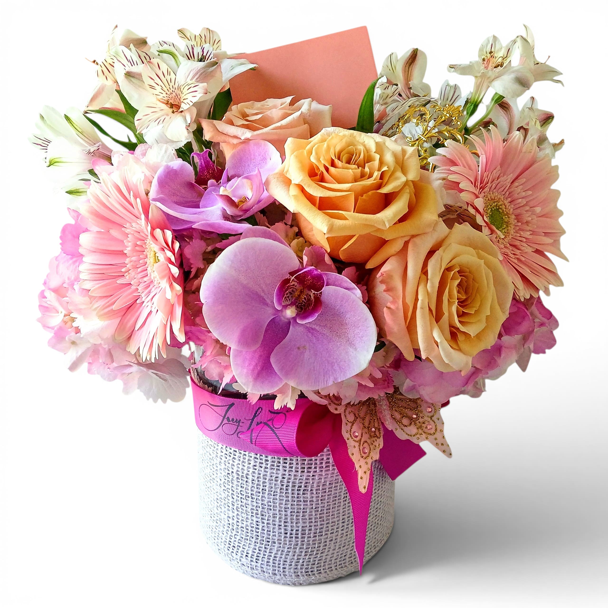 You Are A Peach Pastel Blossoms Haddonfield Delivery - Peach roses and pink gerbera daisies mingle with lavender Phalaenopsis orchids and pale alstroemeria in a soft, rounded bouquet that greets the recipient like a warm, joyful embrace. This flower arrangement for birthdays, anniversaries, Mother's Day, or "just because" moments is designed to make the person you're thinking of feel seen and celebrated-cheerful, romantic, and unmistakably gift-ready for delivery to Haddonfield, NJ.  Arranged in a heavy glass wrapped vase and finished with a vivid pink ribbon and decorative butterfly pick, the composition balances warm peach, pink, purple, and white tones for a delicate springtime look. You'll also notice lush hydrangeas lending volume and a few gerbera daisies for playful contrast. The arrangement arrives in a compact, full shape that's easy to display on a table or mantle; card included for your personal message. Simple care-fresh water and a cool spot-keeps these mixed-color blossoms looking their best for days, making this a thoughtful way to brighten someone's day.