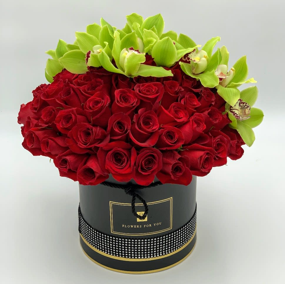 Red roses with green orchids in a black round box