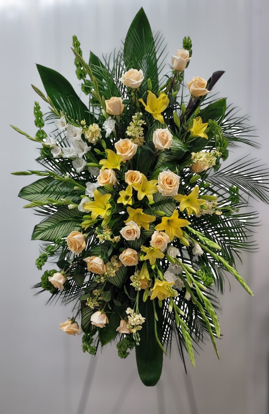 Tall floral spray with cream roses and yellow lilies