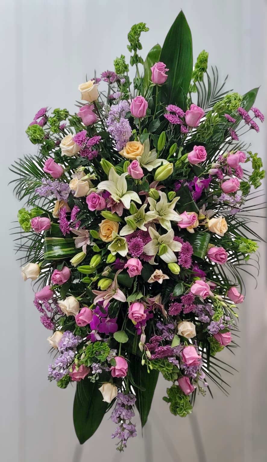 Large standing floral spray with pink and cream roses and lilies
