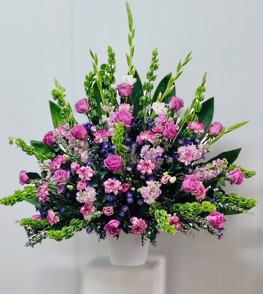 Large bouquet of pink roses and mixed flowers in a white vase
