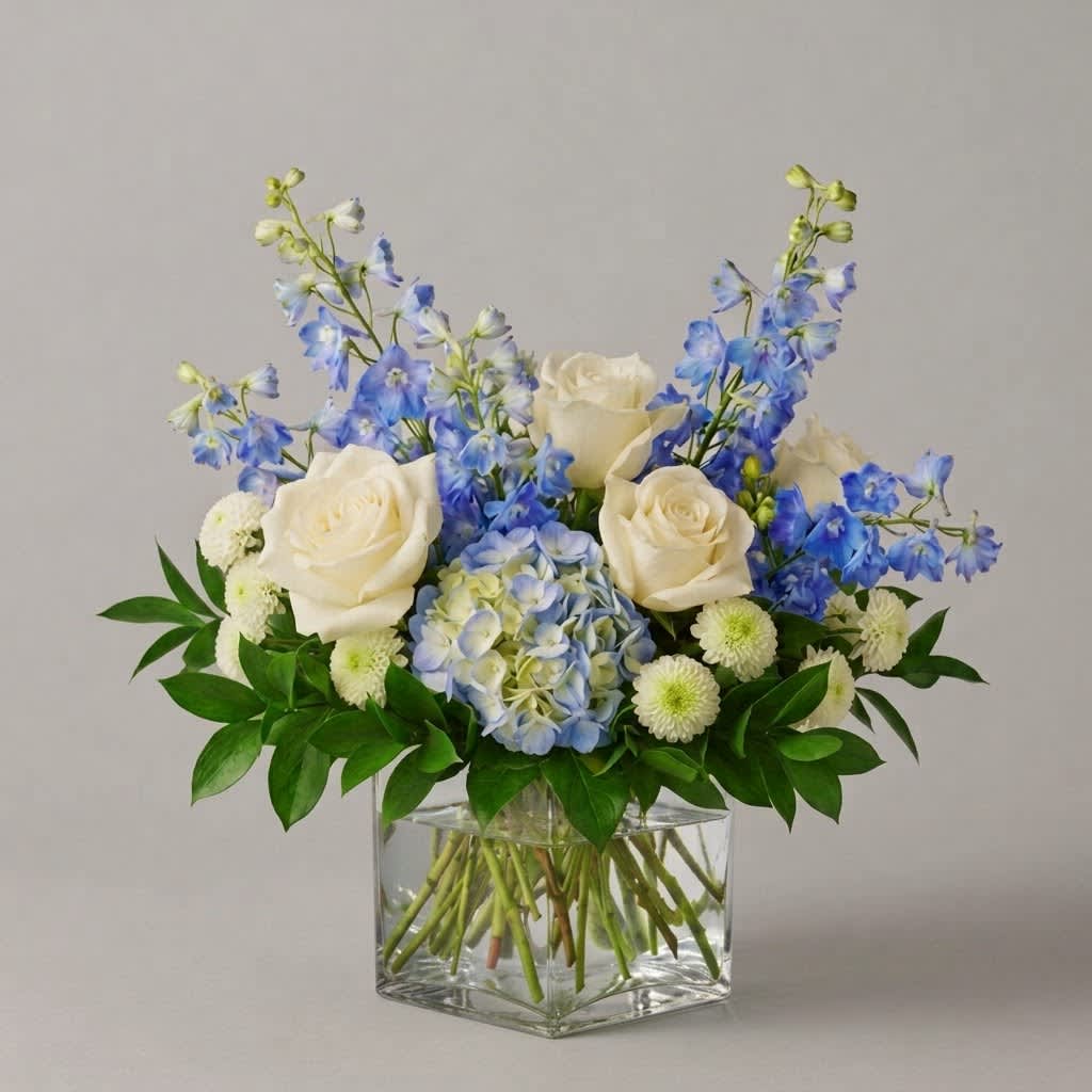 Blue and white floral arrangement in a clear square vase