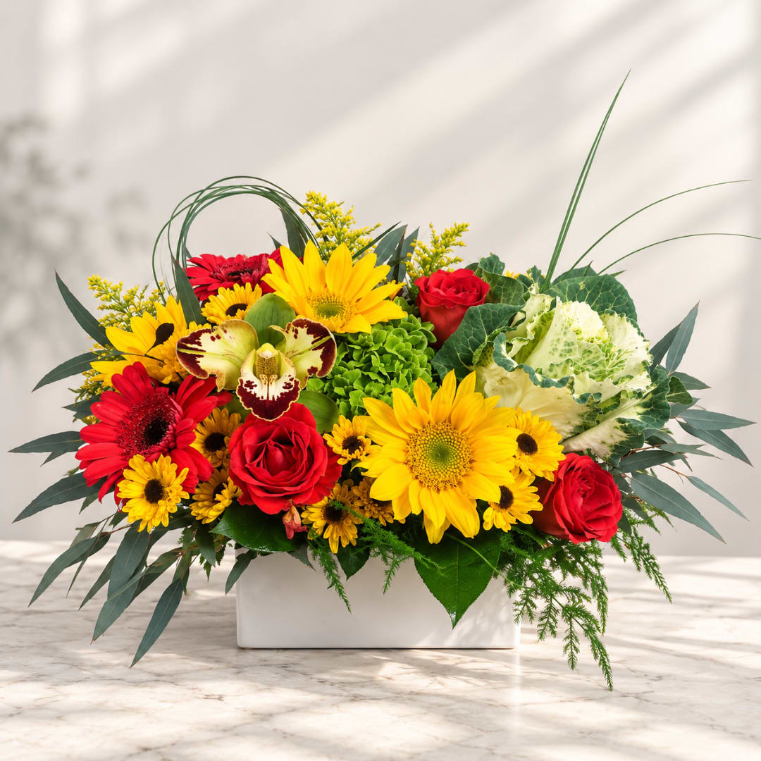 Mixed bouquet in a white rectangular vase with red and yellow blooms