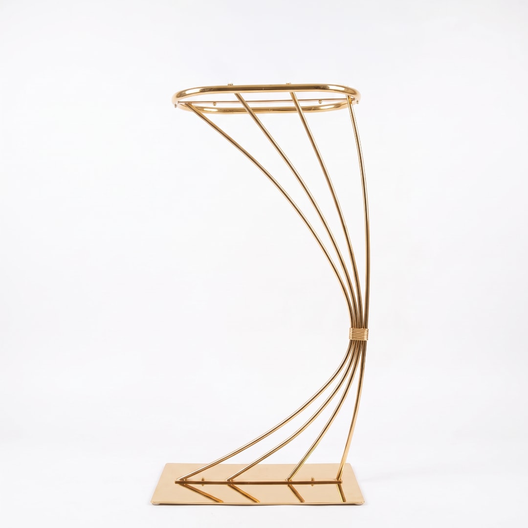 Gold metal floral stand with curved frame on a rectangular base