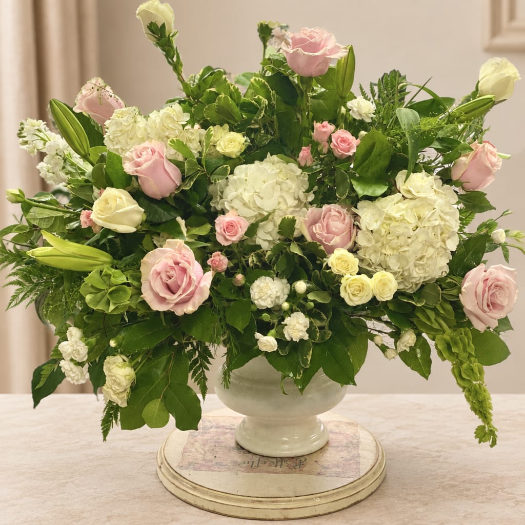 Pink and white roses with hydrangeas in a white vase