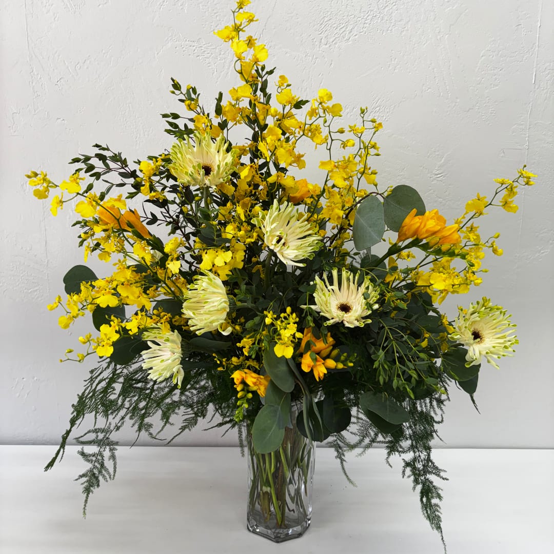 Yellow and white floral arrangement in a clear glass vase
