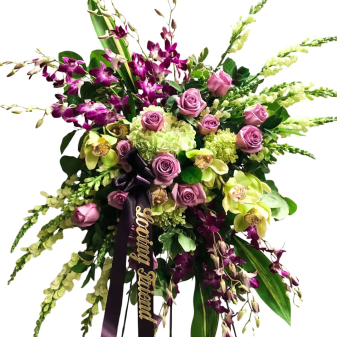 Large bouquet of purple orchids, pink roses, and green hydrangeas with a ribbon