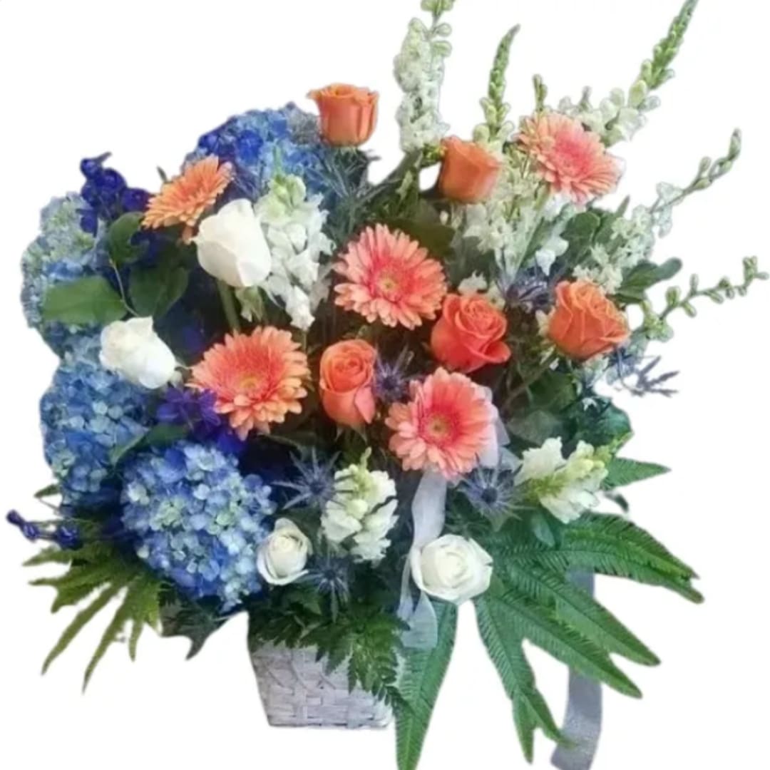 Mixed bouquet with blue hydrangeas, orange roses, and peach gerbera daisies in a basket