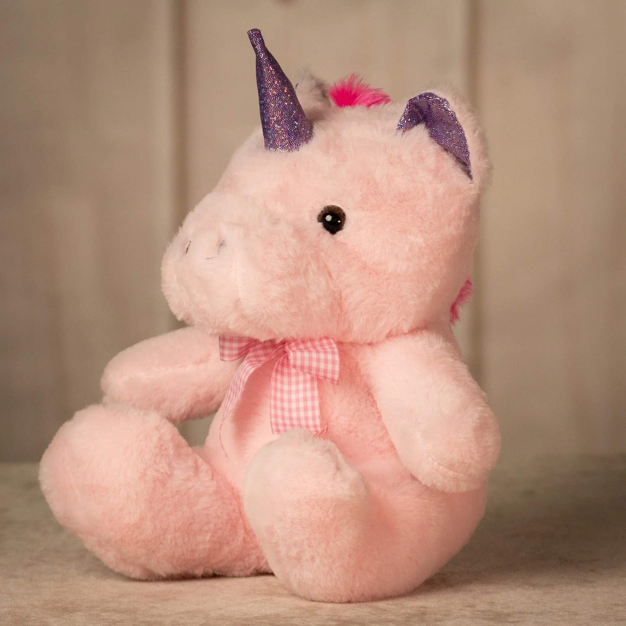 Pink Sparkle Unicorn - A sweet and magical pink unicorn plush with soft fluffy fur, a sparkly purple horn, matching ears, and a cute pink bow. This adorable plush makes the perfect add-on for birthday bouquets, kids’ gifts, get-well arrangements, baby gifts, or any surprise that needs a little extra sparkle and charm. Size - 10 inches tall while sitting Feel - Soft and cuddly, stuffed with hypoallergenic fiber fill