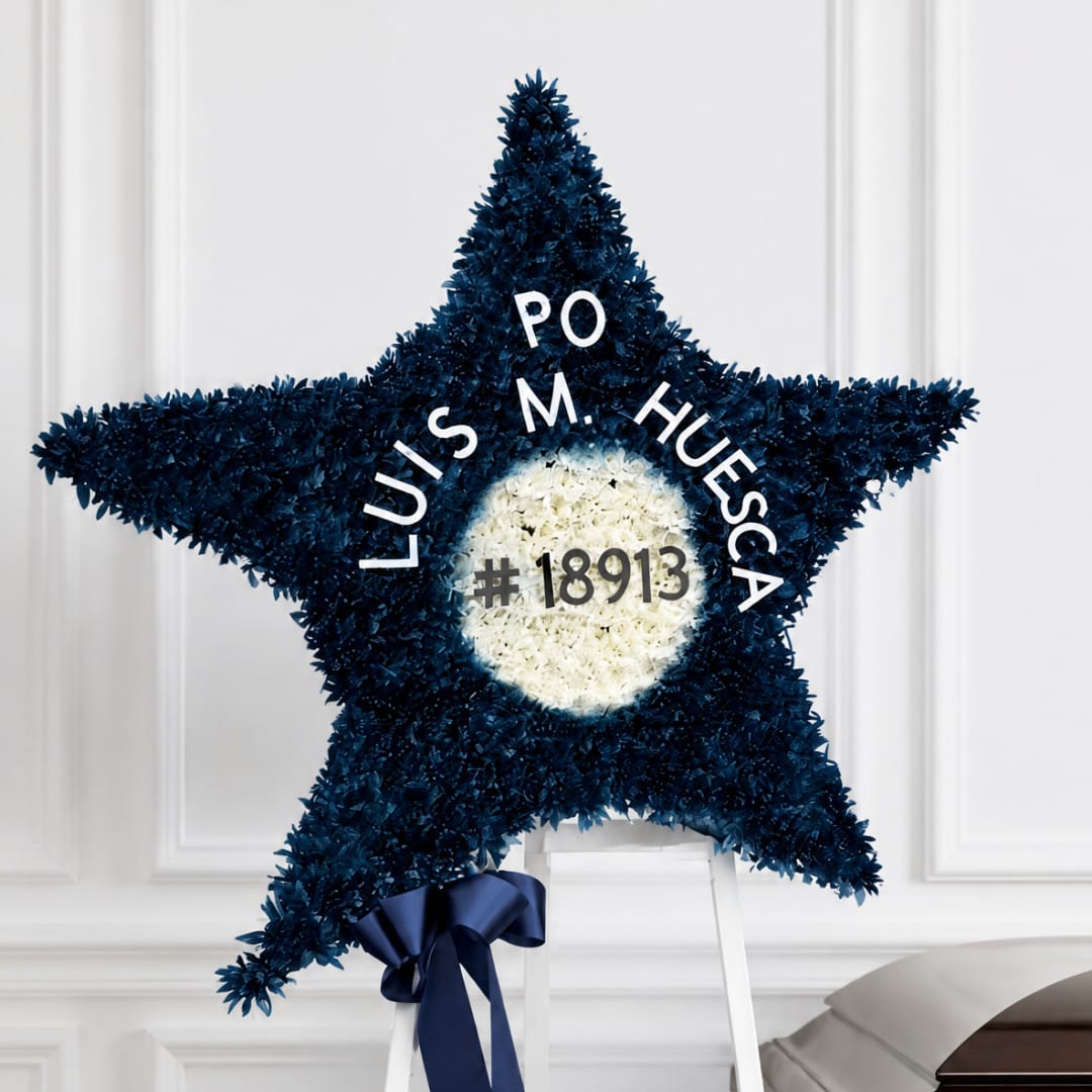 Star-shaped floral tribute on a stand with white center and dark blue flowers