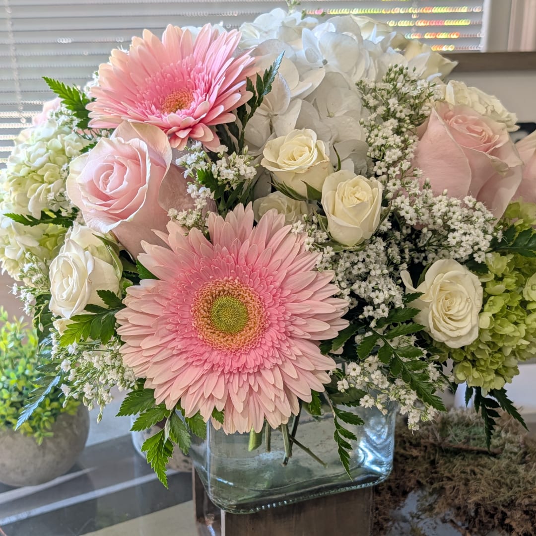 Pink gerbera daisies and white roses in a glass vase