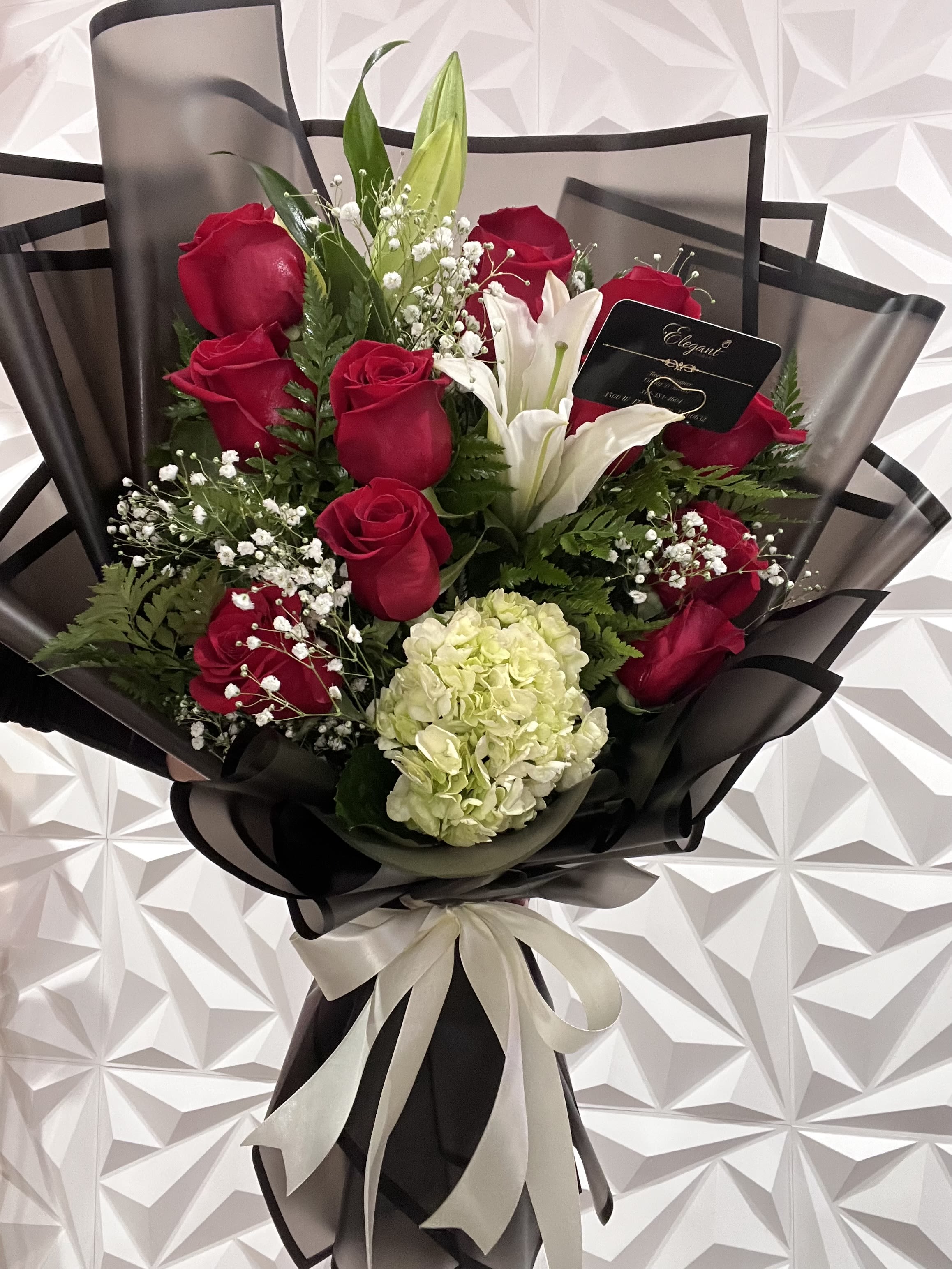 Bouquet of red roses and white lilies with a pale hydrangea bloom