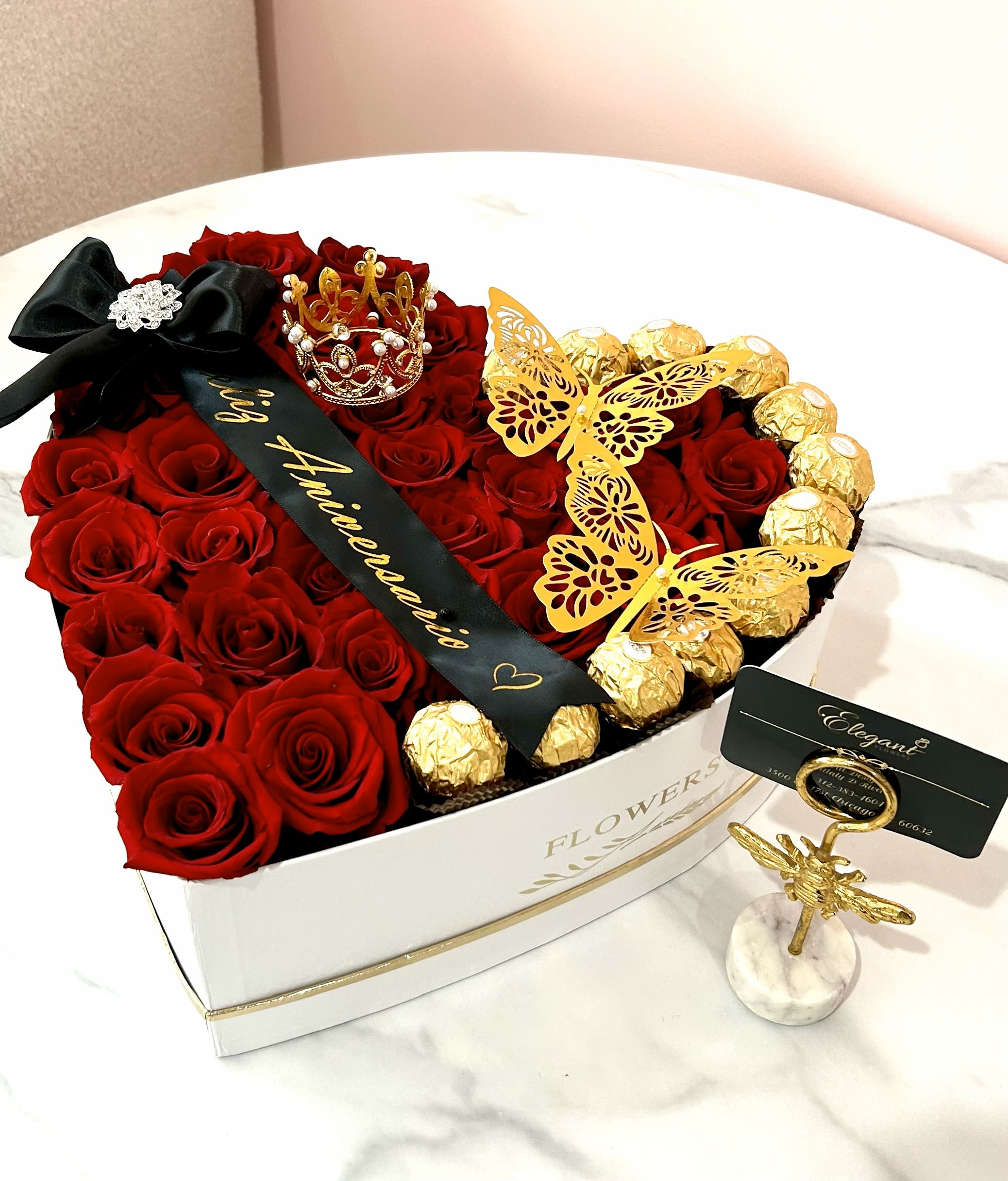 Heart-shaped box of red roses with gold-wrapped chocolates and butterfly decorations