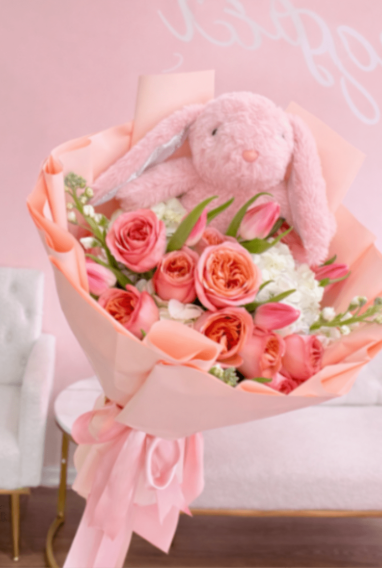 Charming Petal Bunny Collection - A charming bouquet in soft tones featuring elegant peach roses, delicate pink tulips, hydrangeas, and touches of white stock. Paired with a cute plush bunny, this arrangement conveys sweetness, tenderness, and a delicate style—perfect for surprising someone on special occasions.  