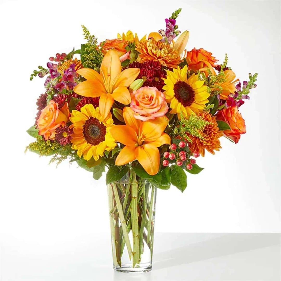 Orange and yellow mixed bouquet in a clear glass vase