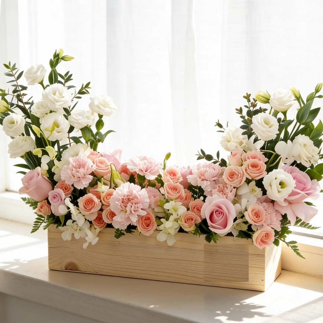 Pink and white floral arrangement in a wooden box